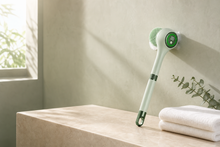 Luma Lather Reach electric bath brush in a calm sage bathroom